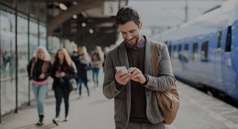 Man on his phone at train station