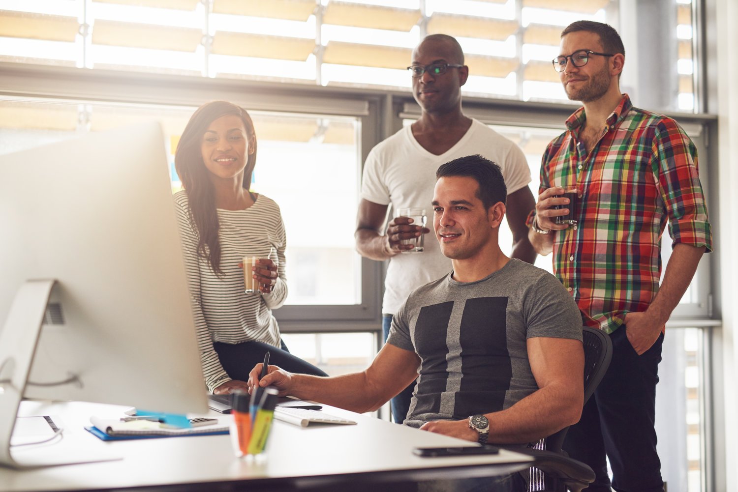 people standing looking at computer screen